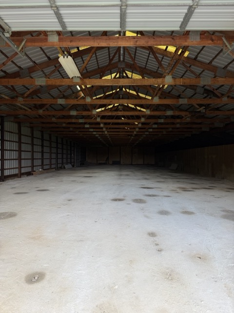 Interior of the seasonal storage barn with timber trusses and open floor